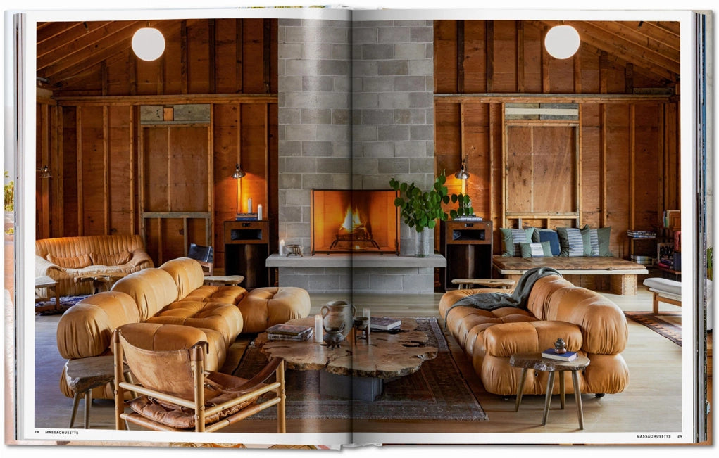 Open book showing a interior design layout of a wooden cabin with a stone fireplace, plush brown leather couches and asymetrical wooden coffee table. 