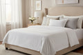 White pillow with decorative stitching on a white background
