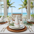 Three triangular white napkins with colorful embroidery on a gray background