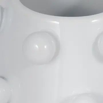 Close-up of a white ceramic vase with a textured surface
